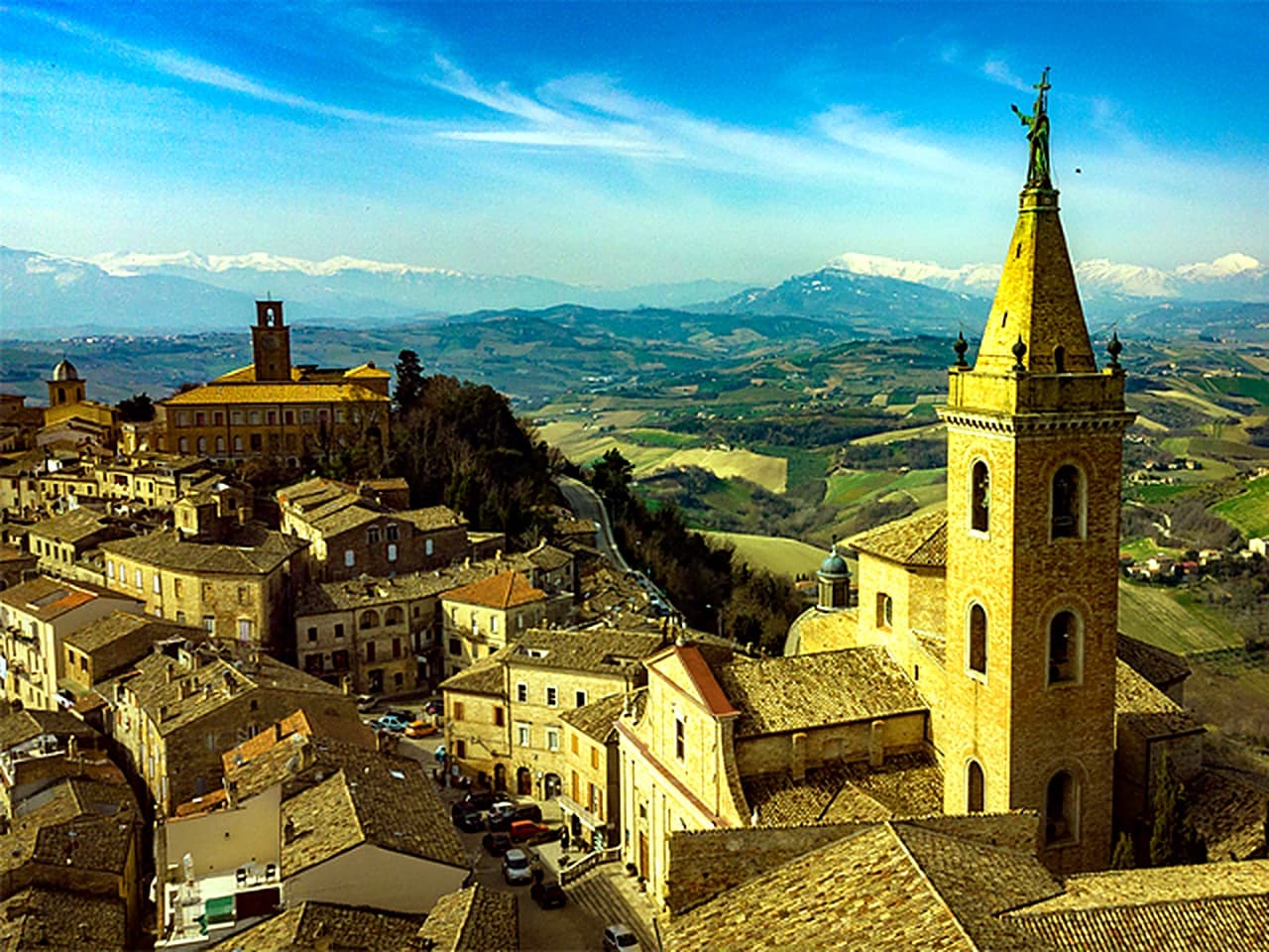 Veduta di Ripatransone con il campanile della Cattedrale dei Santi Gregorio e Margherita · tetti del borgo medievale e colline verso i Sibillini sullo sfondo