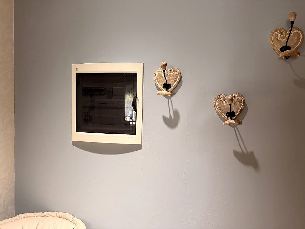 Il quadro elettrico appeso al muro vicino all'uscita di casa, accanto agli appendi-cappotti a forma di cuore