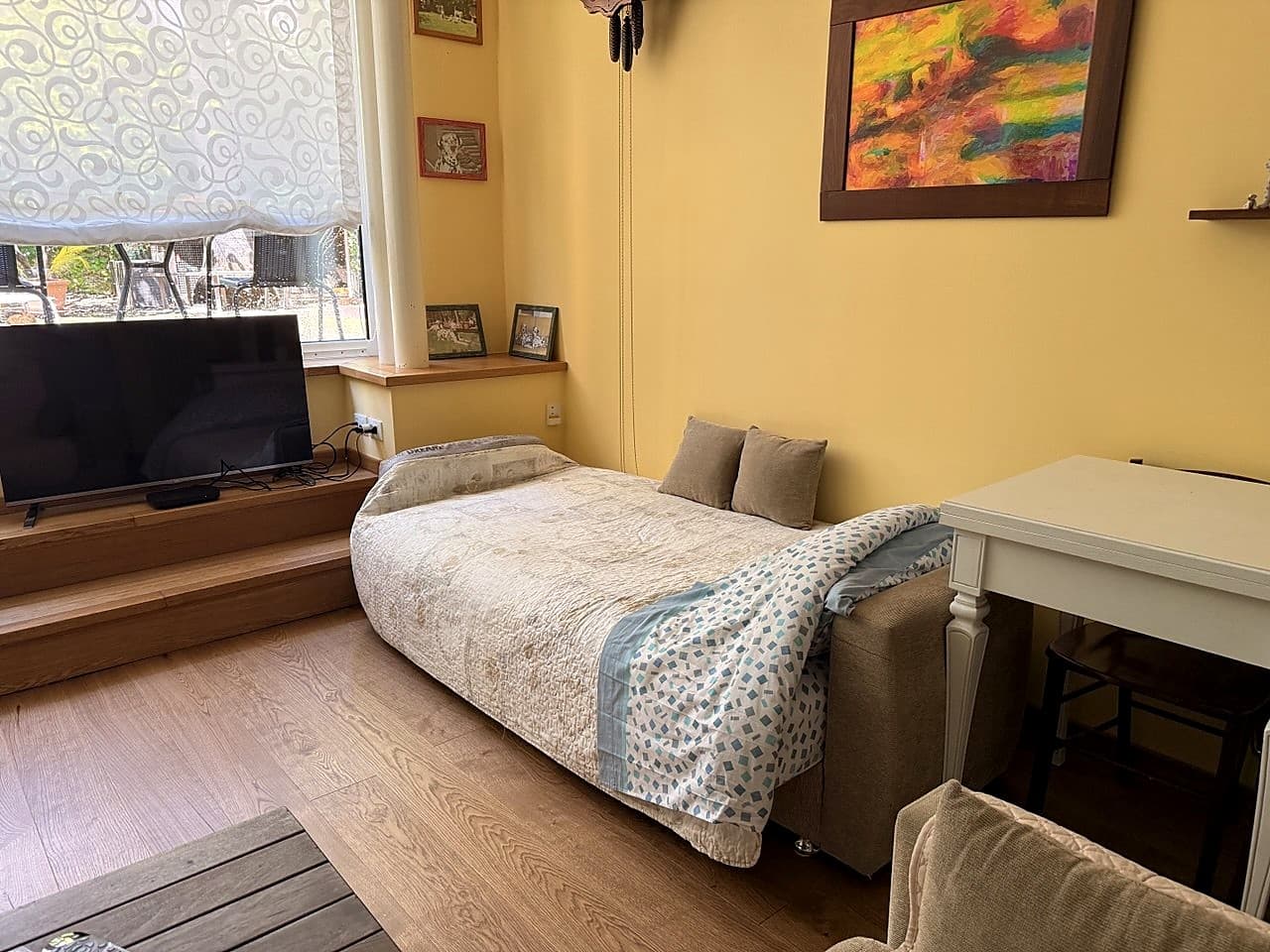 Il salotto verso il lato della Smart TV, della grande vetrata sul giardino e del tavolo quadrato pieghevole